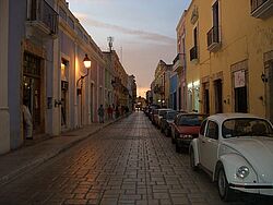 Blick durch eine kopfsteingepflasterte Straße in Campeche, Mexiko, im Abendlicht.