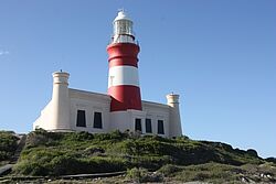 Ein rot-weiß gestreifter Leuchtturm trohnt über dem südlichsten Punkt des afrikanischen Kontinents, dem Kap Agulhas
