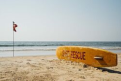Strand mit Rescue-Board und Fahne in Goa
